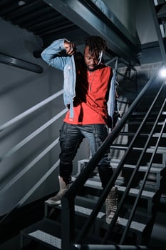 African American man putting on jacket on metal stairs photo