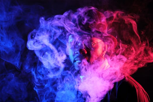 Stylish black man in smoke in neon light photo