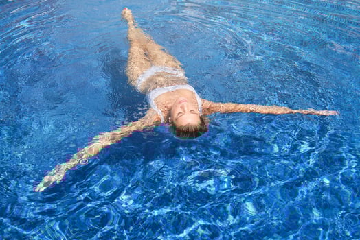 Woman with eyes closed swimming in pool photo