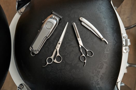 Set of various tools on black barber chair photo