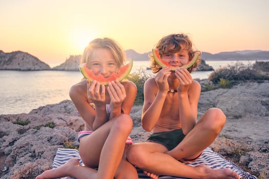 Happy brother and sister during picnic at seaside photo