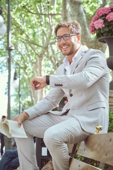 Cheerful elegant businessman with book in hand waiting for meeti photo