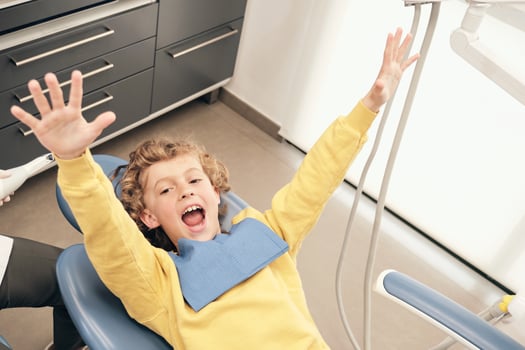 Excited boy on dental chair photo