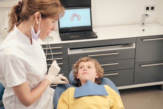 Dentist with boy in medical clinic photo