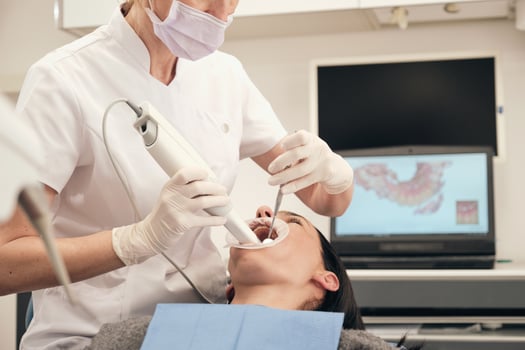 Crop stomatologist scanning teeth of woman in clinic photo