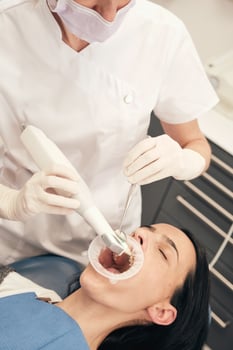 Dentist scanning oral cavity of patient in clinic photo