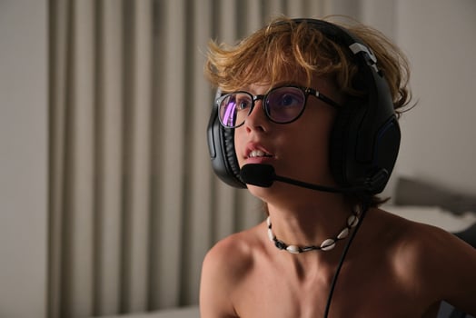 Crop young man in headphones and glasses sitting on a chair photo