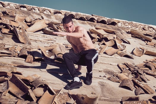 Man trying descending from uneven tiled roof photo