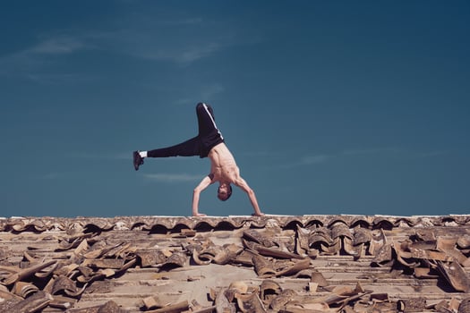 Flexible young man performing two hands rotation while dancing breakdance photo