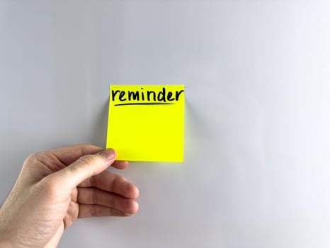 Person hangs reminder on refrigerator photo