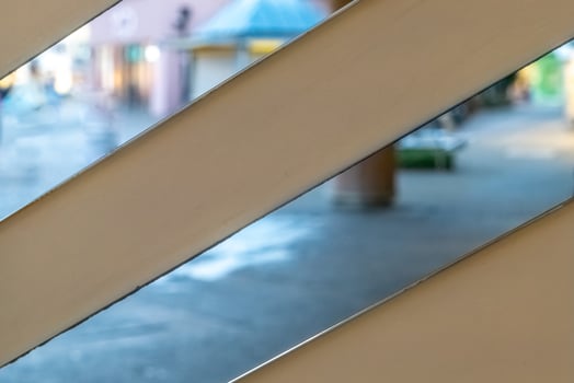 View of a colorful street through wooden slats during a quiet afternoon, showcasing vibrant architecture and a serene atmosphere photo