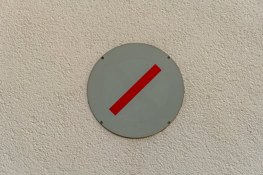 No entry sign displayed on a textured wall indicating restricted access for vehicles and pedestrians photo