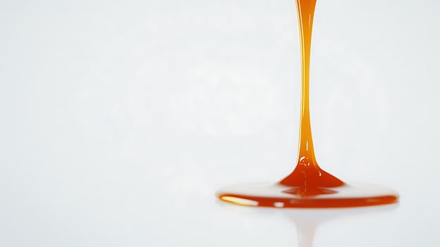 Orange Liquid Pouring Down Onto A Reflective Surface photo
