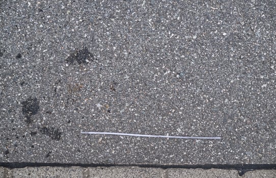 Thin Piece of Plastic on Asphalt Surface photo