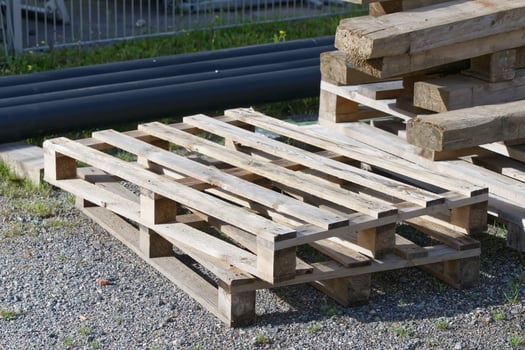 Stack of Wooden Pallets on Gravel Surface photo