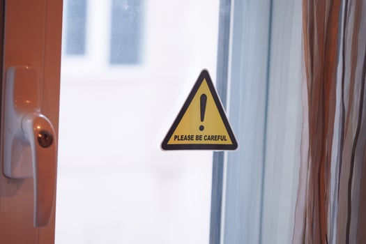 Warning sign reminding to exercise caution near open window photo