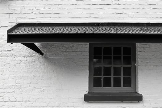 A close-up of a window and overhanging roof. photo