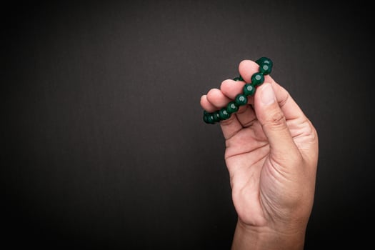 Jade bangles or bracelets in hand against a black background. Close-up. photo