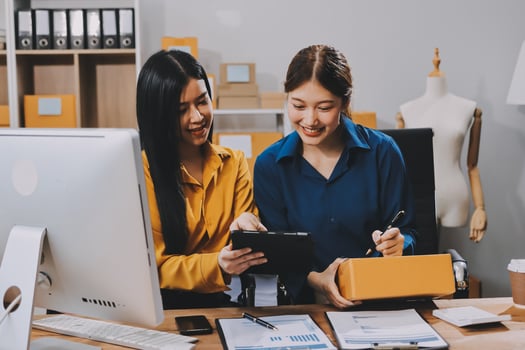 Two women working on a computer in an office photo
