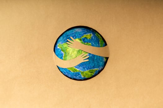 World Earth Day Concept. Green Energy, ESG, Renewable and Sustainable Resources. Environmental Care. Paper Cut as Arms Embracing Green Globe. Top View photo
