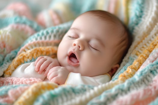 A peaceful Caucasian baby sleeping soundly wrapped in a colorful knitted blanket. photo