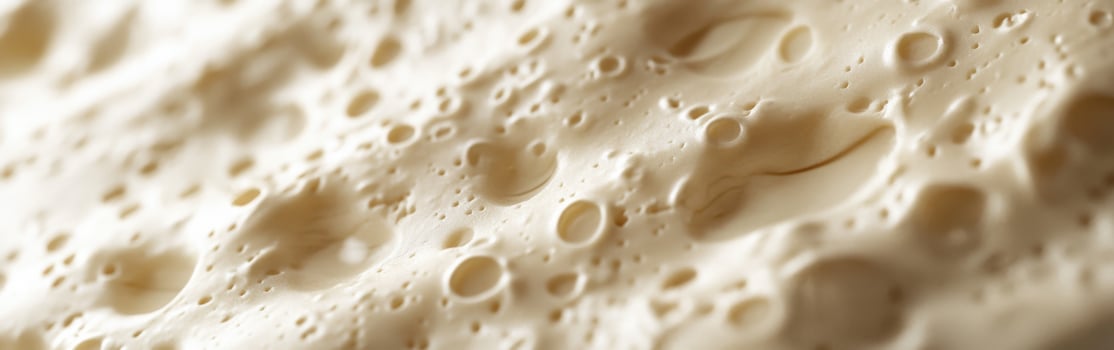 Soft cheese with smooth texture and varied surface features close-up photo