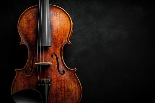 Beautiful wooden violin resting against a dark background photo