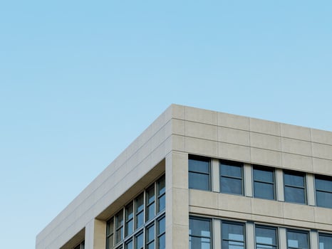 Glass facade of a modern building with geometric design and clear sky. photo