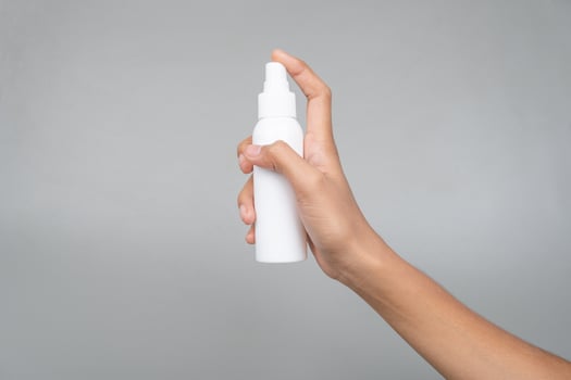 Quick-Absorbing SPF Spray Sunscreen Mockup in Womans Hand for Sun Care Isolated Background photo