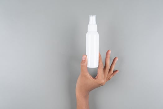 Quick-Absorbing SPF Spray Sunscreen Mockup in Womans Hand for Sun Care Background photo