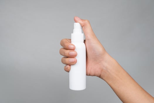 Quick-Absorbing SPF Spray Sunscreen Mockup in Womans Hand for Sun Care photo
