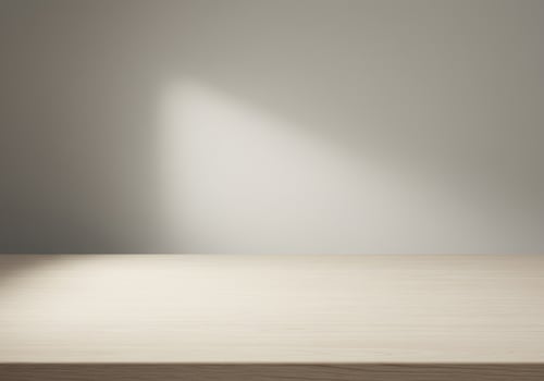 Light Illuminates Empty Wooden Tabletop Against Neutral Wall photo