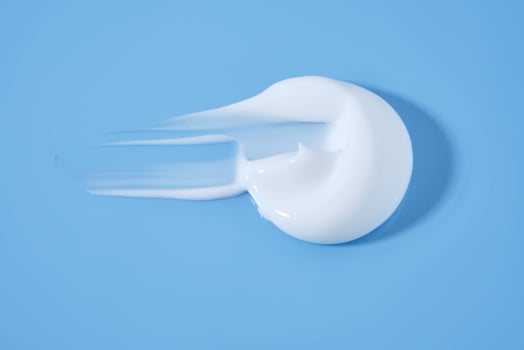 A smear of white cream on a blue background. photo