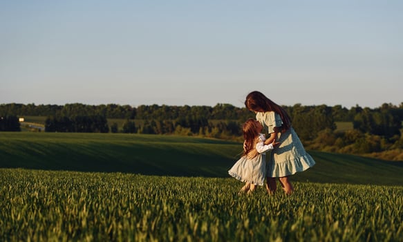Little girl is running to the woman.. Mother and daughter have fun outdoors on the field at summer photo