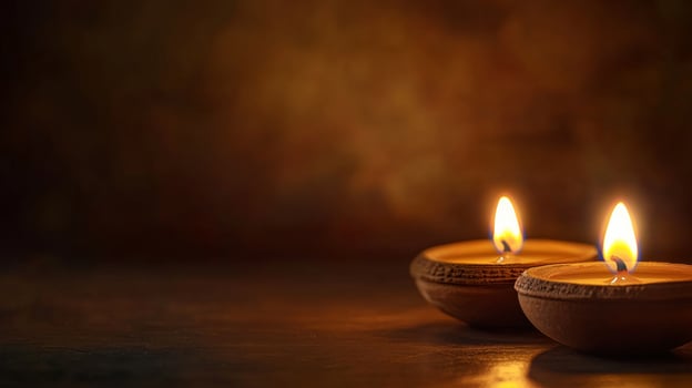 Two burning candles on a wooden table photo