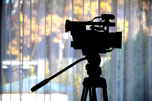 Camcorder On A Tripod Over Cloth Background photo