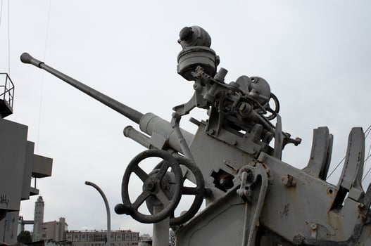 Old Anti Aircraft Machine Gun Over City Buildings photo