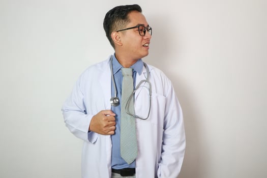 Doctor Asian male over isolated white background looking side photo