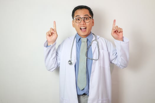 Medical concept of professional male doctor pointing with hands on copy space photo
