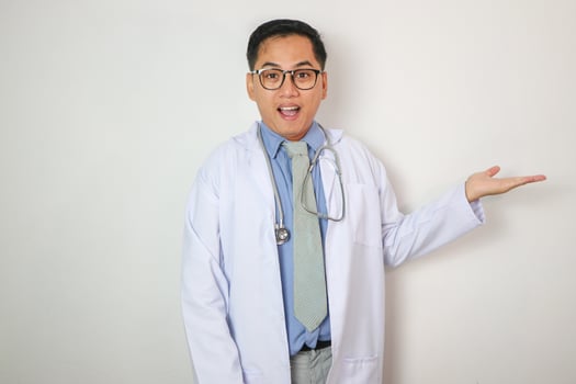 Asian man doctor medical professional holding something in empty hand, isolated on blue background with Clipping paths for design work empty free space photo