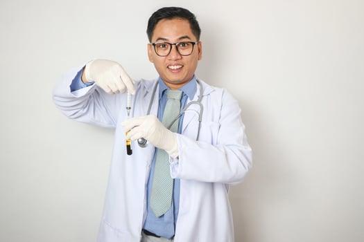 young asian doctor with stethoscope and blood sample tube on white background photo