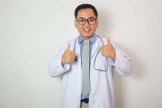 Portrait of Asian Young man doctor therapeutic advising abstract blur with focus show showing thumbs up with white background photo