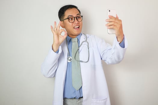 Asian Male Doctor Making Phone Call Isolated on White Doctor photo