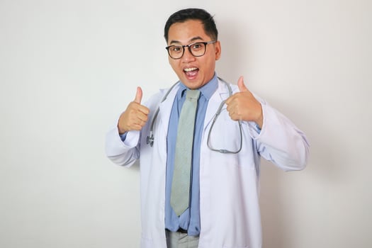 Smiling Young Asian Doctor Showing Thumb Up photo
