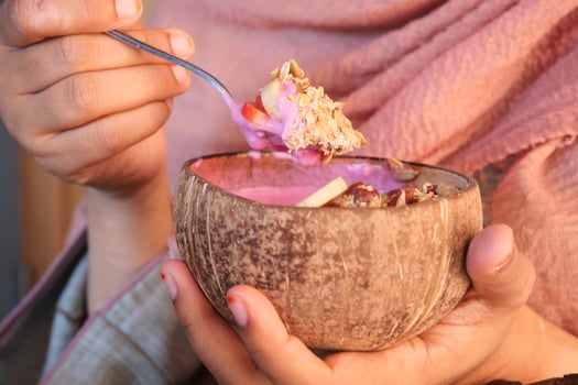 Eating colorful dessert from a coconut bowl in a cozy setting photo