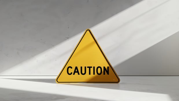 Caution sign on a white surface with shadows photo