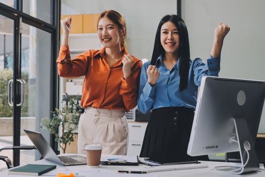 Two women in an office celebrating photo