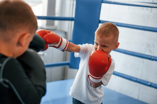 Fighting on the ring. Boys training boxing in the gym together photo