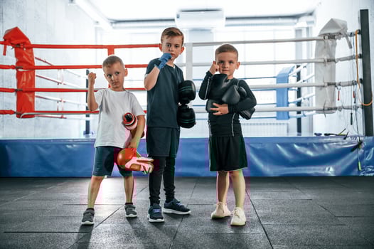 Standing and posing for a camera,. Boys training boxing in the gym together photo