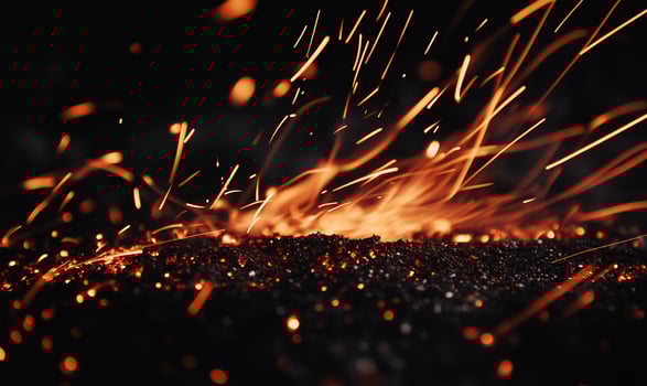 A close up of sparks flying off of a black background photo